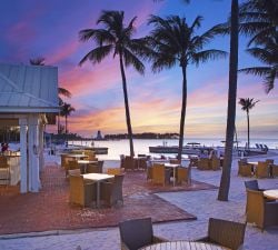 Outdoor dining area overlooking the ocean at sunset