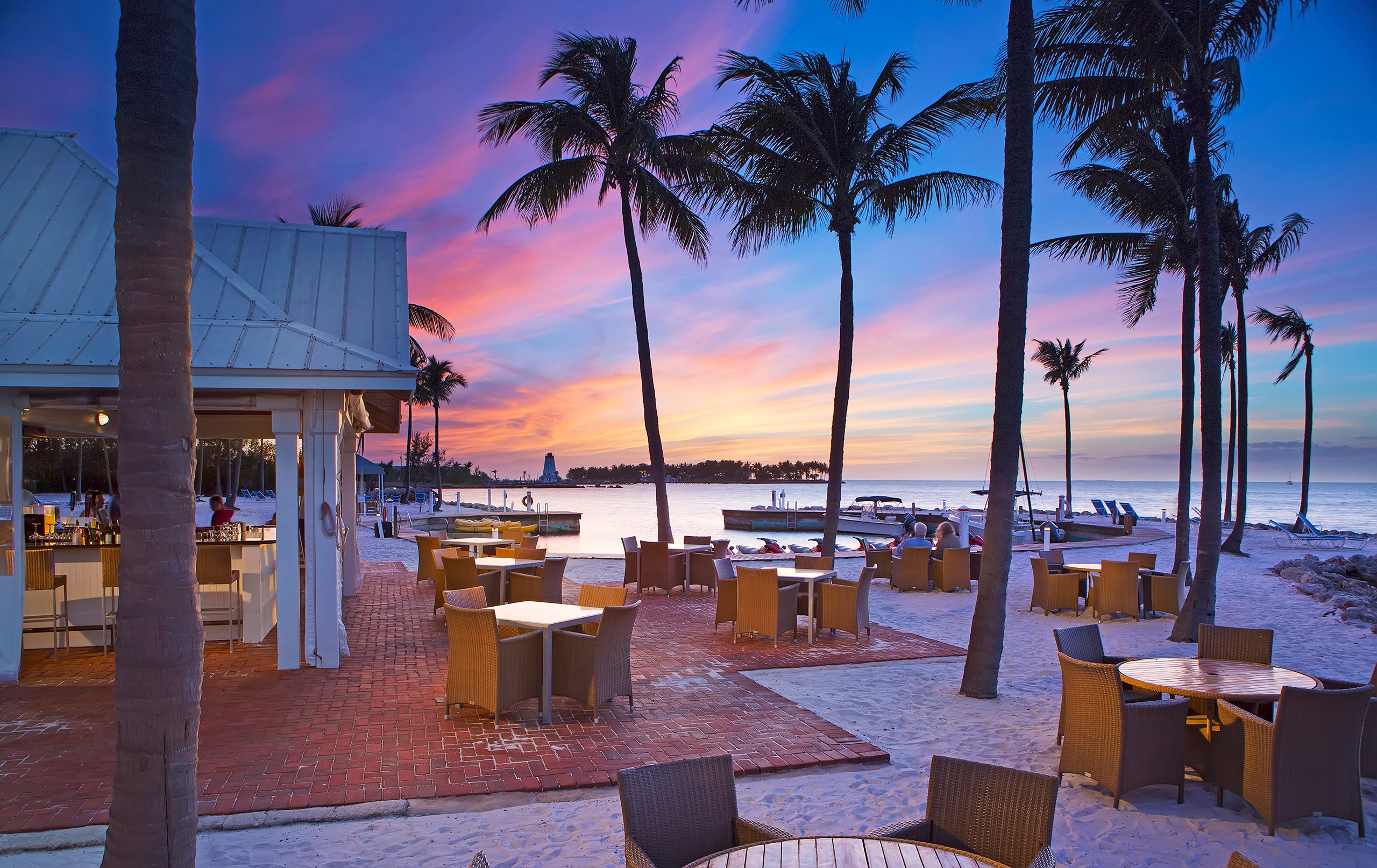 Outdoor dining area overlooking the ocean at sunset
