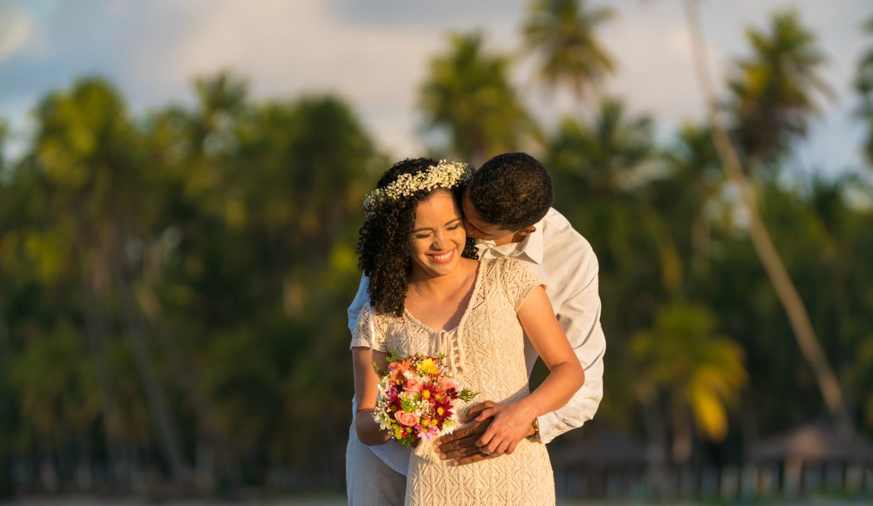 Newlyweds on beach with bouquet and flower crown