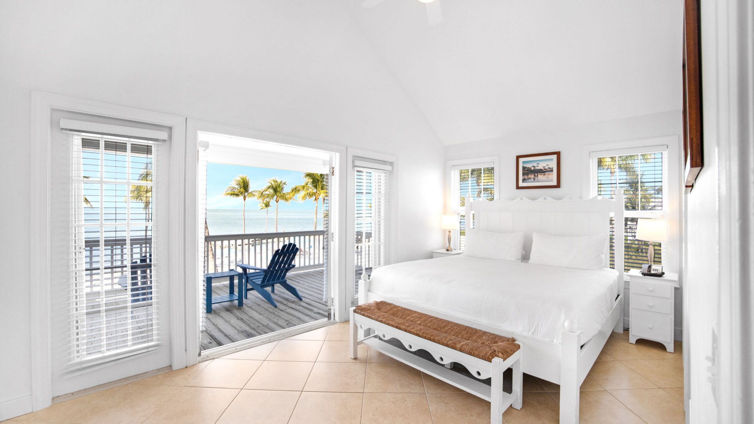 A king bed and ocean views from the primary bedroom of a 3-Bedroom Beachfront Villa at Tranquility Beach Beachfront Resort, in the Florida Keys.