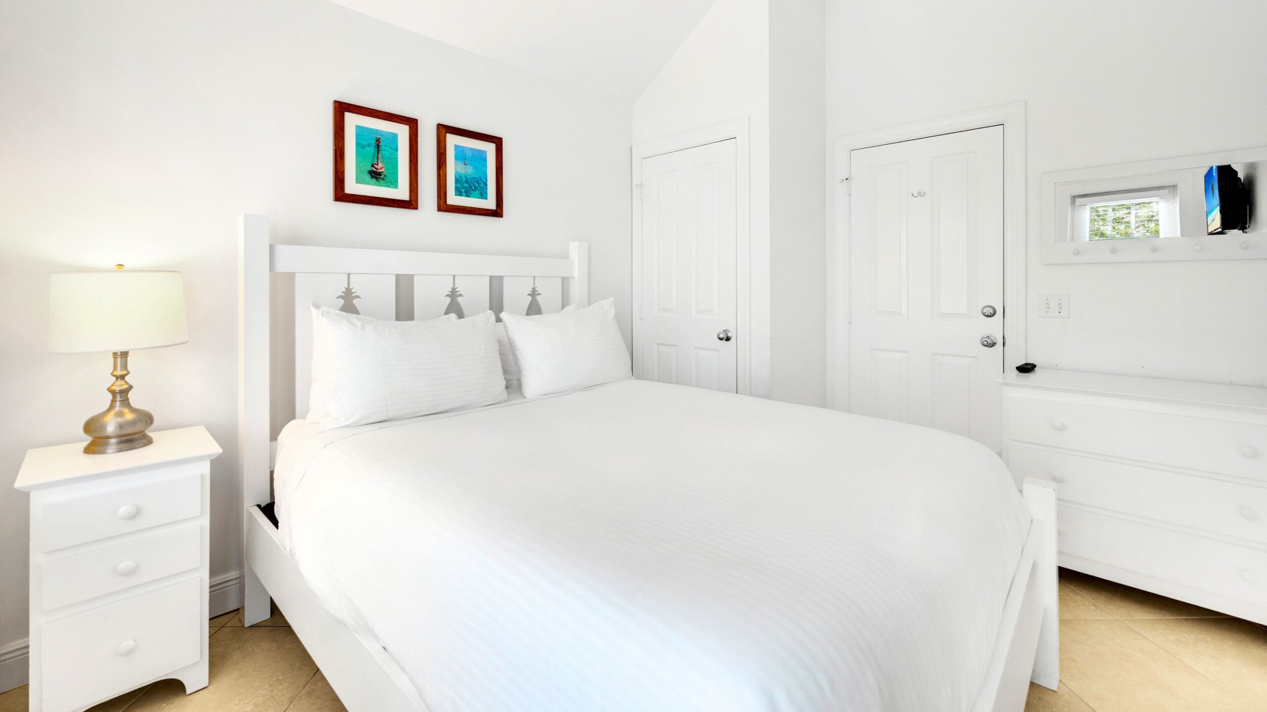 A bedroom with a queen bed in a 3-Bedroom Beachfront Villa at Tranquility Beach Beachfront Resort, in the Florida Keys.