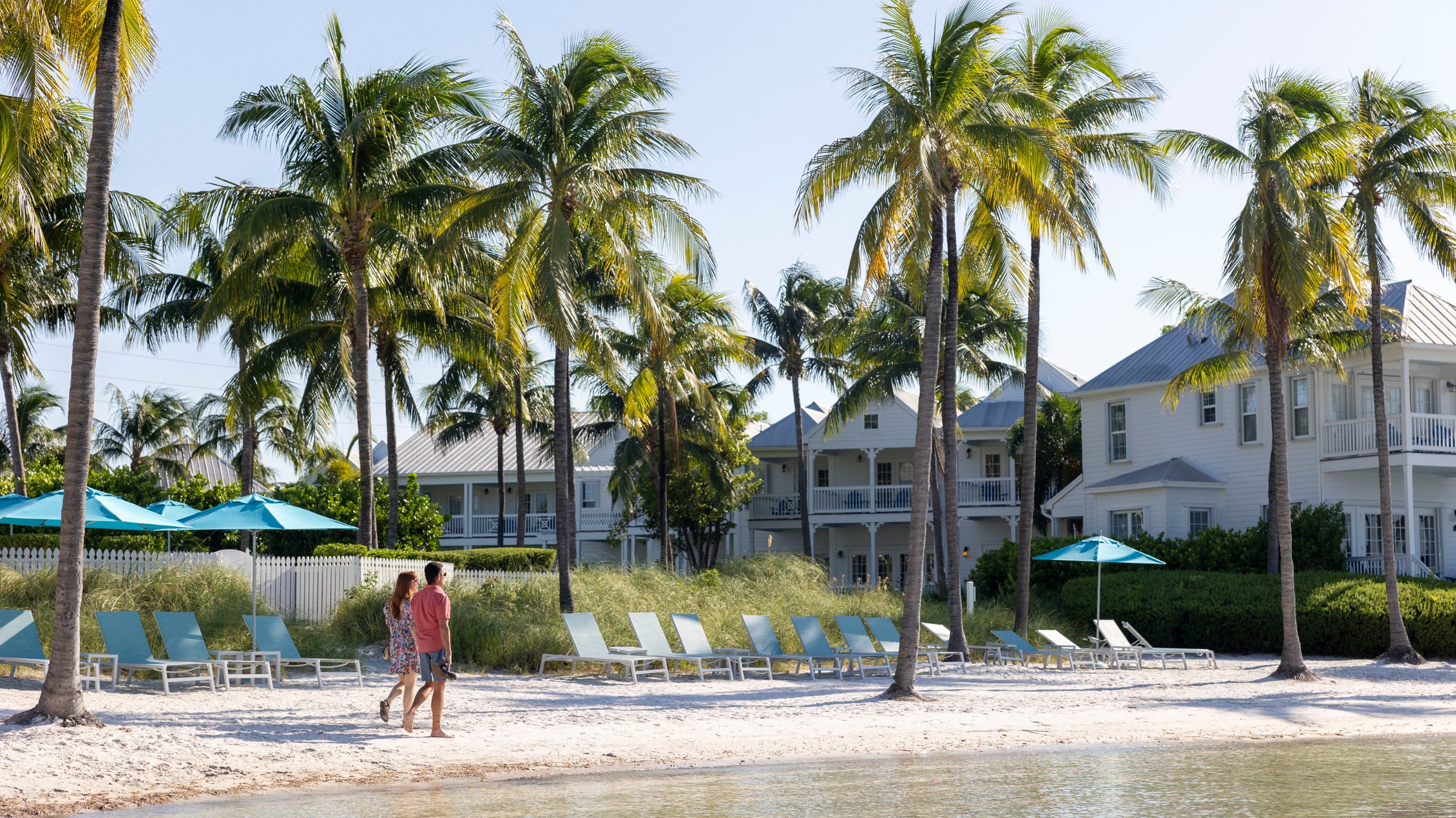 A couple walks on the private beach at Tranquility Bay Beachfront Resort, in the Florida Keys.