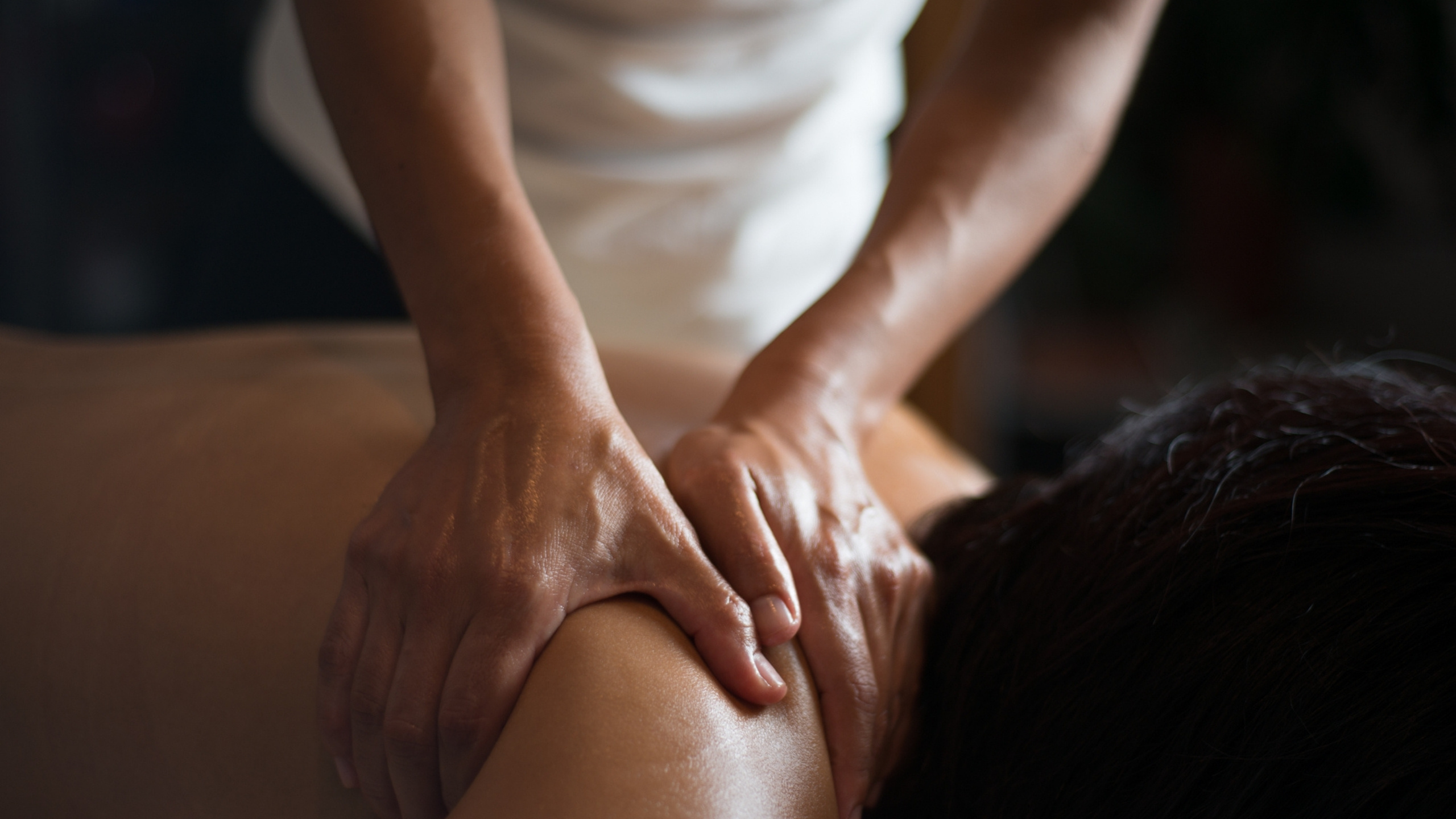 Masseuse massages shoulders.