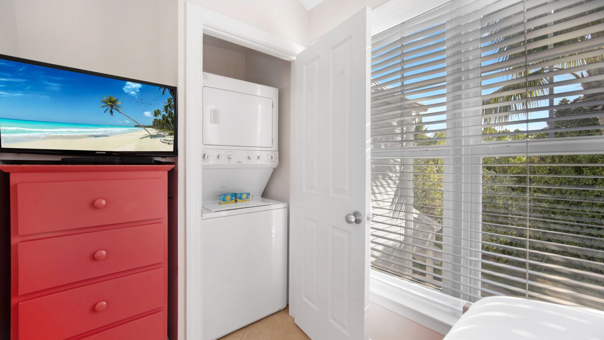 view of bedroom in 2-bedroom water view villa featuring a washer & dryer amenity