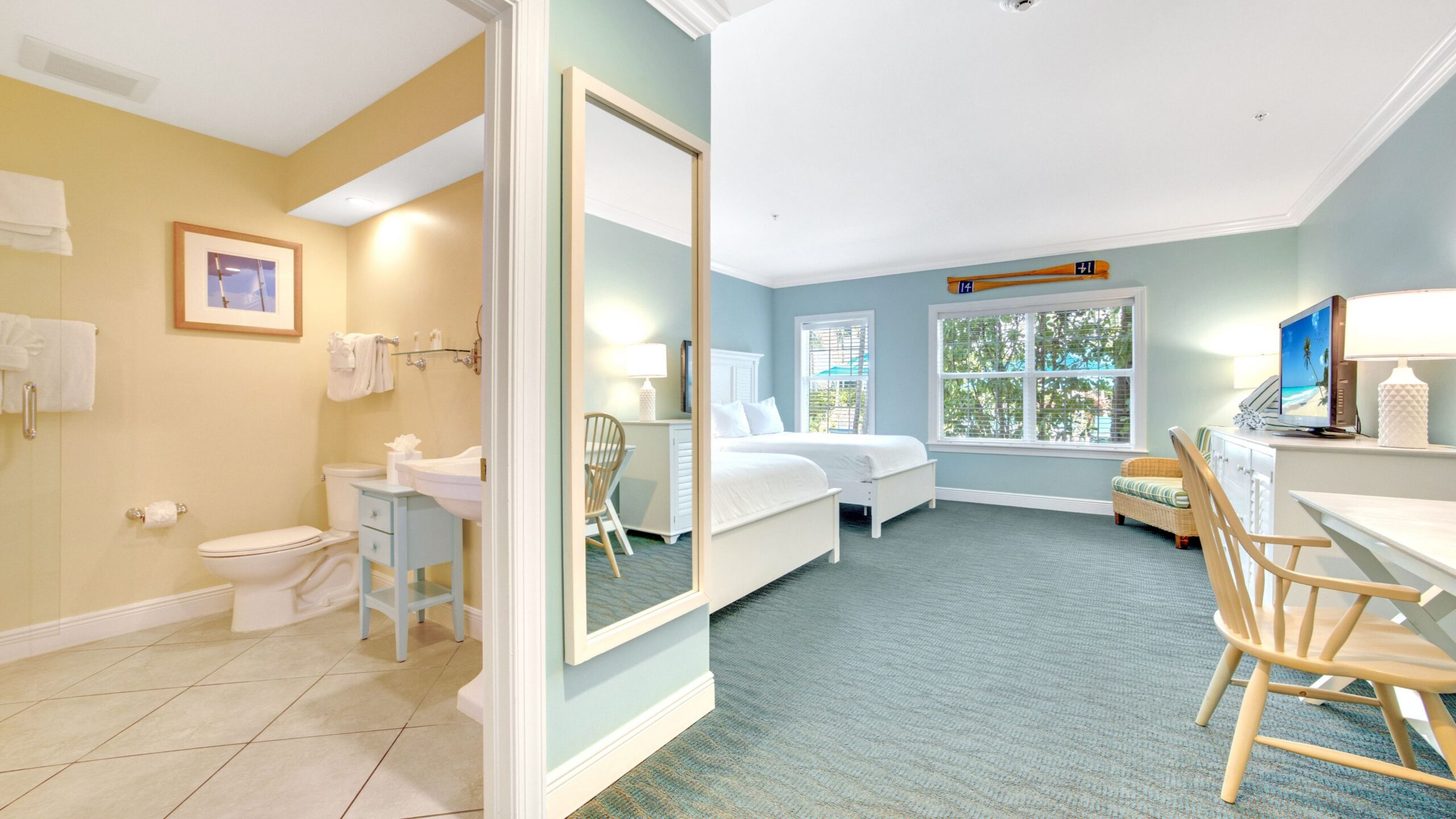 Bathroom and bedroom interior of a Tropical Garden Double Queen Hotel Room at Tranquility Bay Beachfront Resort, in the Florida Keys.