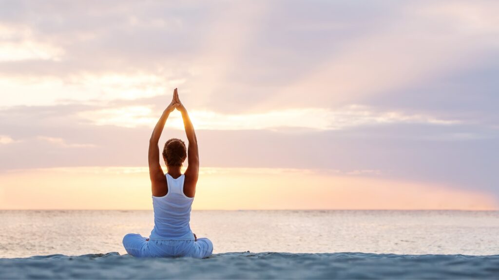 Woman does yoga on the beach at Tranquility Bay Beachfront Resort, in the Florida Keys.