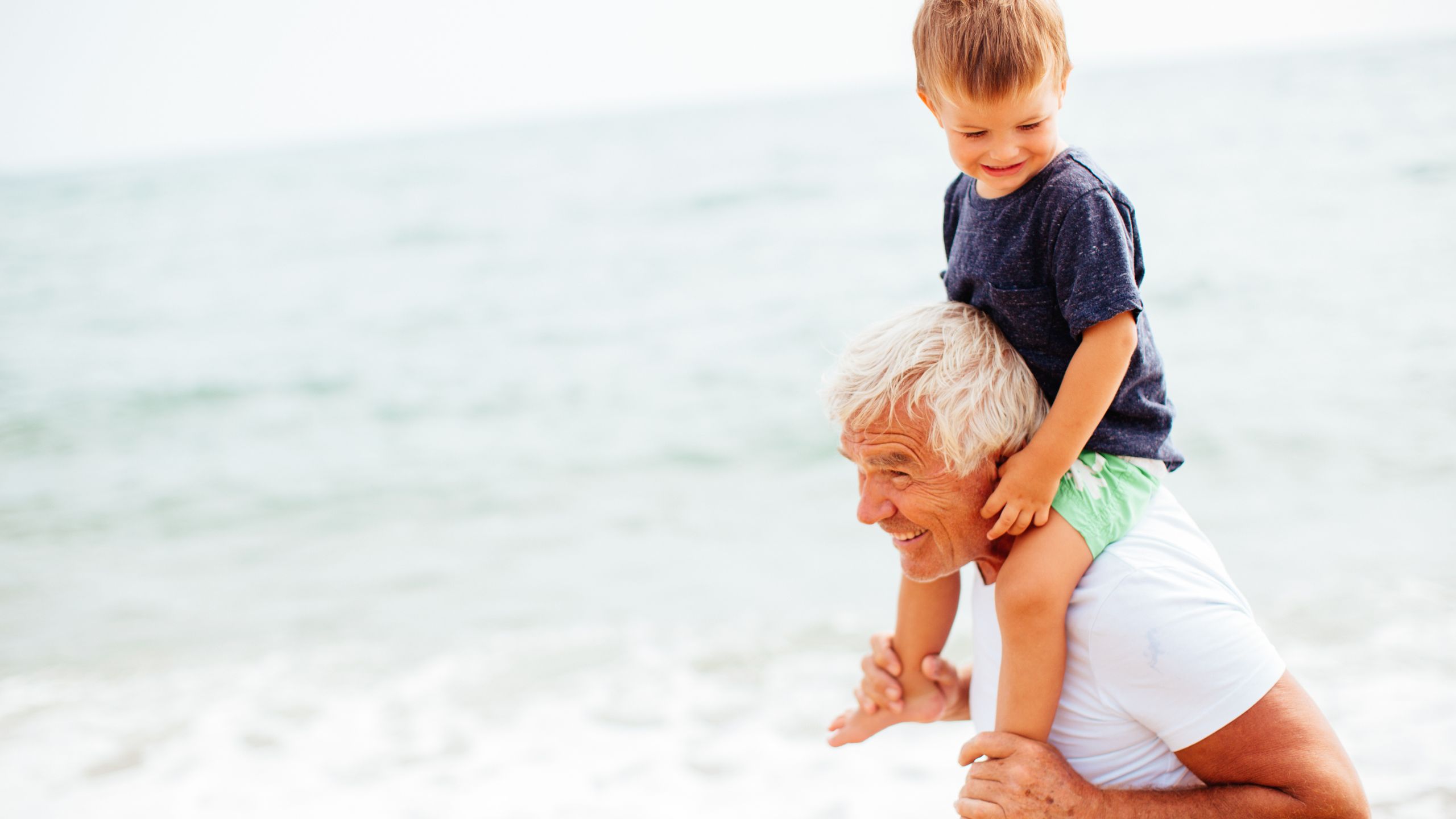 A grandpa and kid at the beach at Tranquility Bay Beachfront Resort, in the Florida Keys.